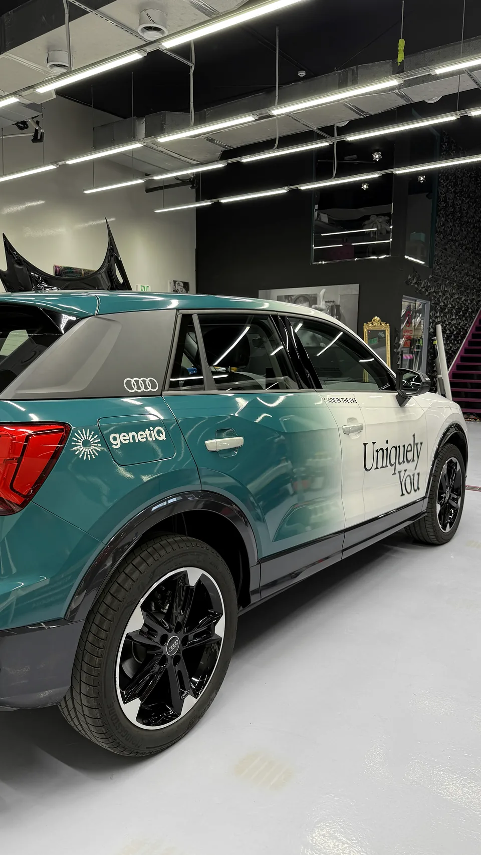 Rear three-quarter view of the same Audi SUV with matching Genetiq fleet graphics