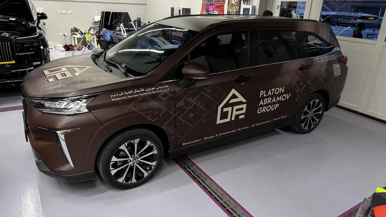 Brown Platon Abramov Group commercial SUV with architectural fleet graphics in Dubai