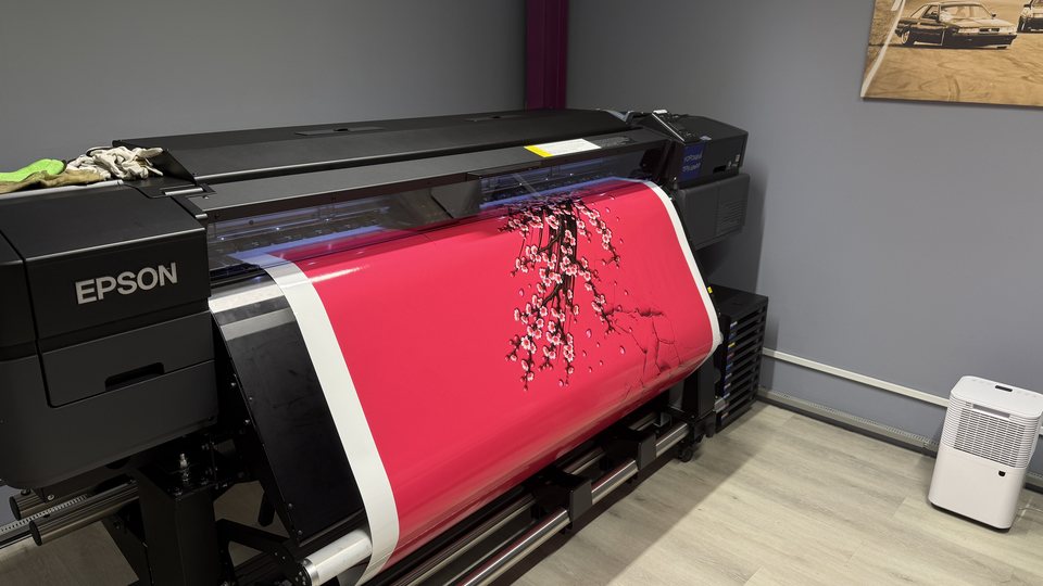 Large-format Epson printer producing printed graphics in the JUST GRAPHICS Dubai studio