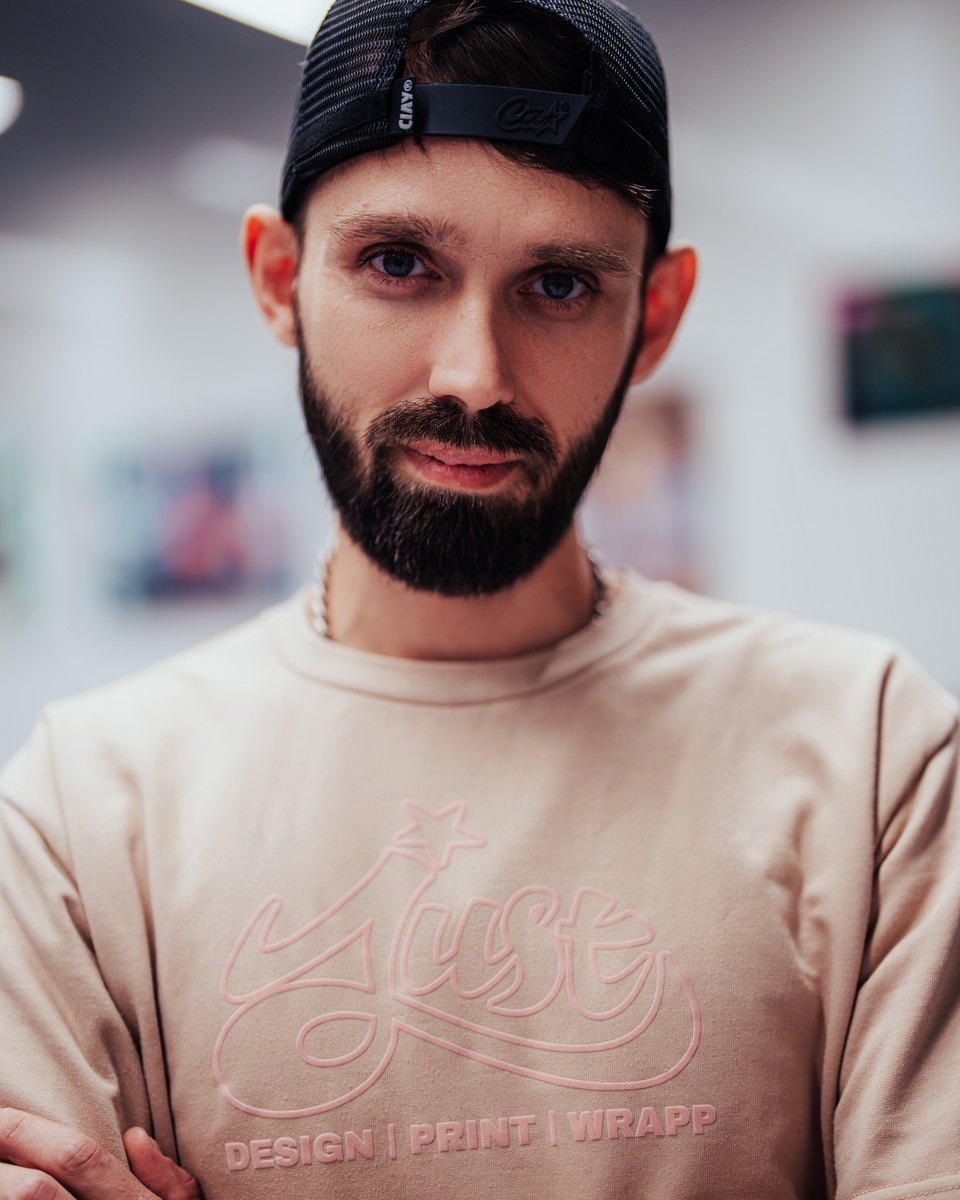 Jacob, co-founder of JUST GRAPHICS, wearing a branded studio shirt